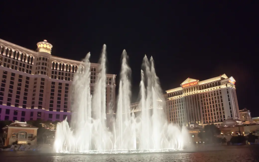 Fuente de aguas danzantes con múltiples chorros iluminados de noche
